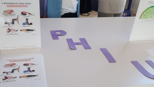 Purple cut out letters P, H, I and U laid out on the table