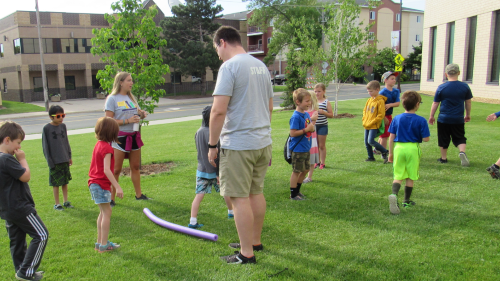 Minnesota State Mankato Rec and Read instructors with students outside on a green lawn playing a group game