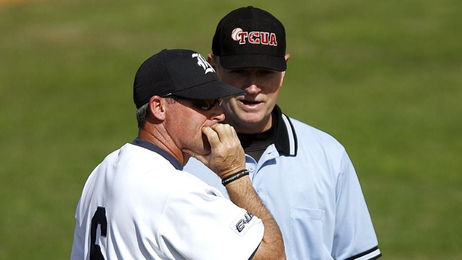 Two baseball coaches talking on the field