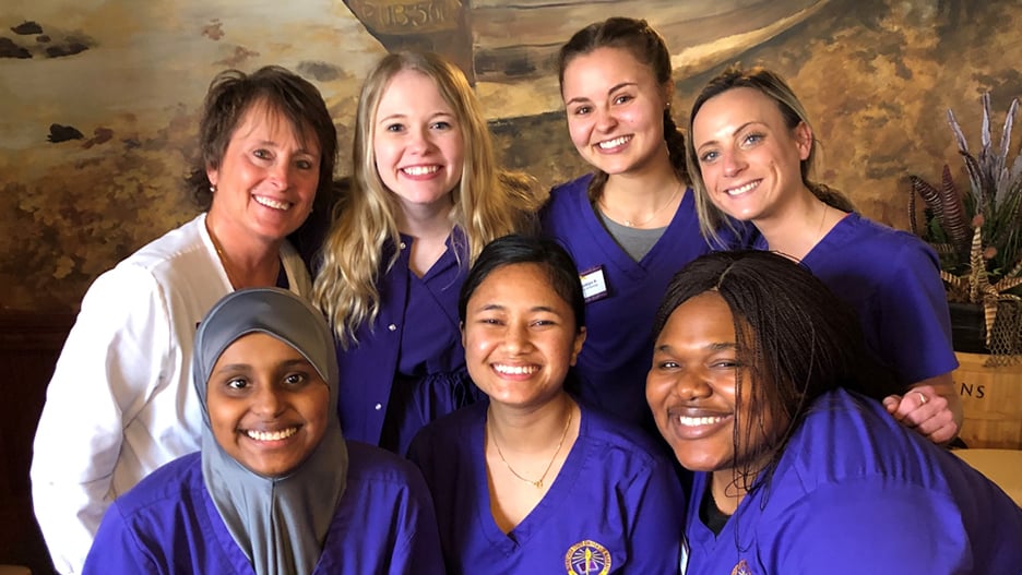 Six female nursing students with a registered nurse posing with smiles