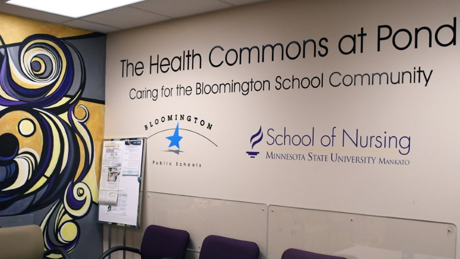 "The Health Commons at Pond Caring for the Bloomington School Community" on a wall with the School of Nursing Minnesota State University, Mankato word mark