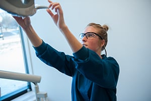 Dental student adjusting x-ray equipment in the radiology lab