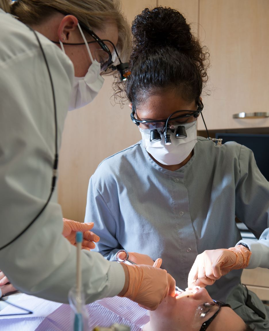 Dental student and faculty with patient in dental chair at the clinic