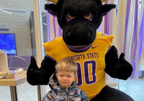 Stomper posing with young child in the public dental clinic lobby