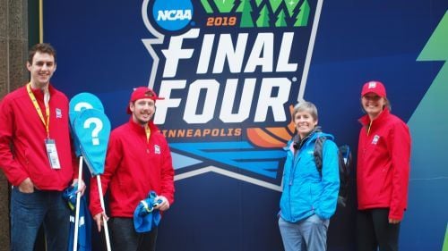 Faculty and students posing next to the NCAA 2019 Final Four logo in Minneapolis