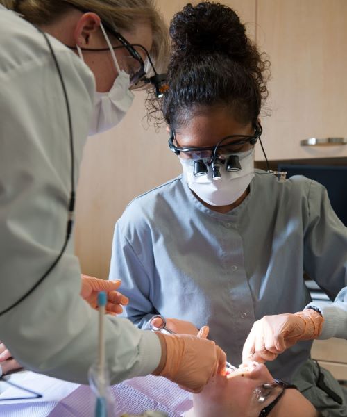Dental student and faculty working with patient in dental clinic