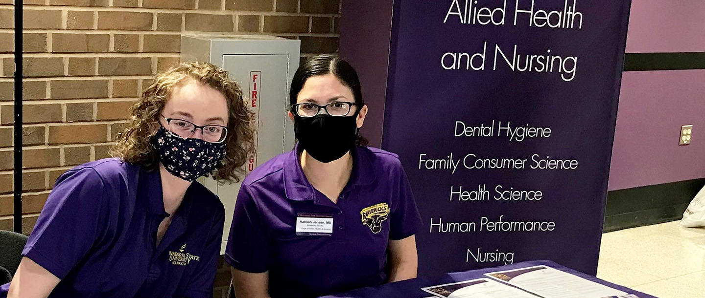 Two Allied Health and Nursing advisors at a career fair table 