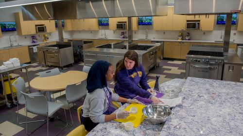 Two students working at the counter in the food lab