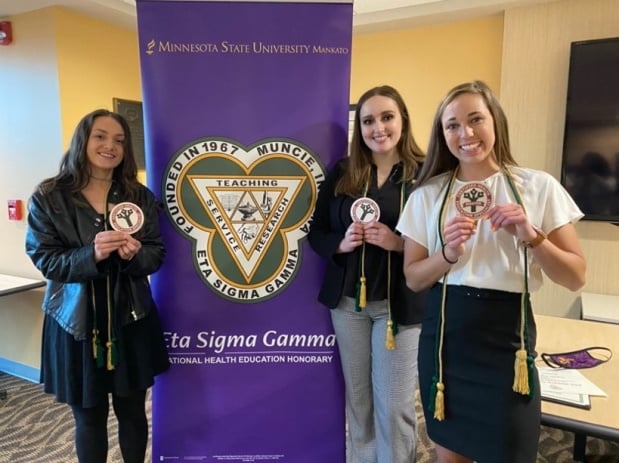 a group of women holding medals