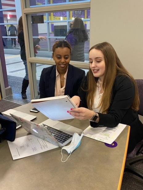 two women looking at a notebook