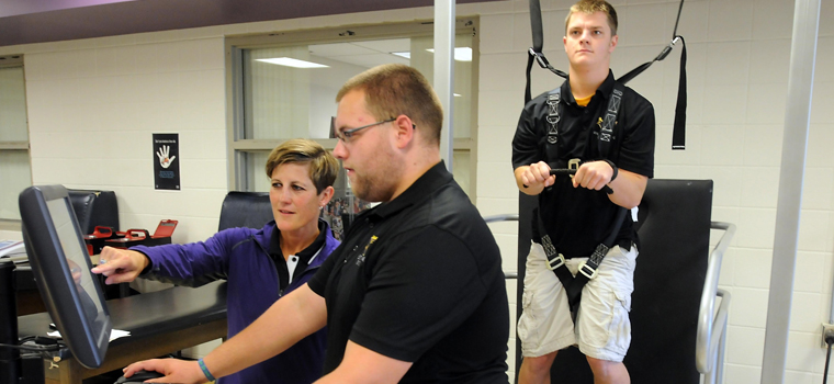 Athletic training faculty and student examining a patient