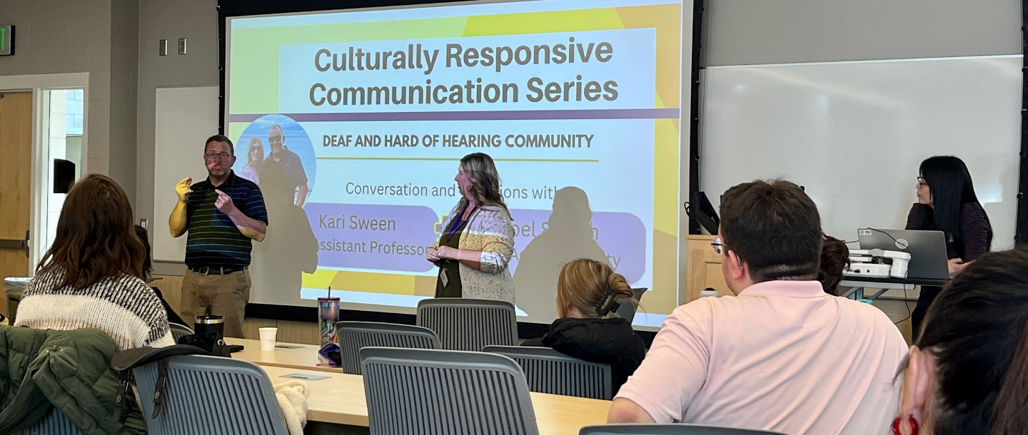 2 people presenting and one person in front of the laptop to change slides for the Culturally Responsive Communication Series about, Deaf and Hard of Hearing community in front of an audience