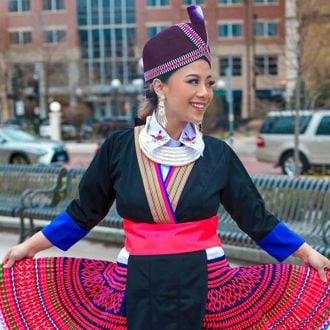 Samantha Vang Florentino posing outside wearing a traditional and colorful outfit