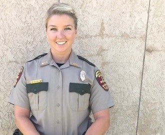 Chelsey Bechel posing outside in her Department of Natural Resources uniform