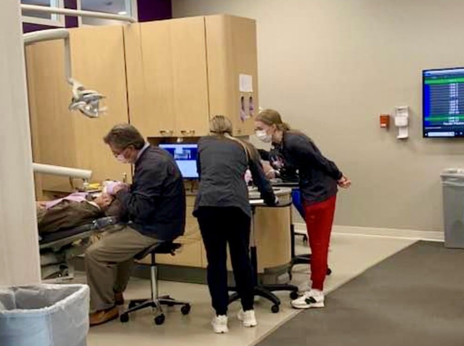 Students and dentist performing a dental exam