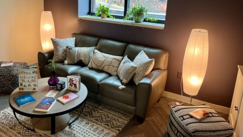 Seating area with couch, soft lighting and coffee table in the Equity Engagement space