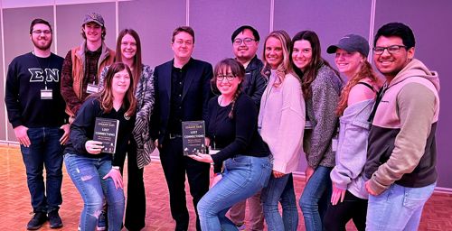 RPLS students and author Johann Hari posing together with two students holding an award in their hands