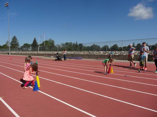RPLS students leading activity with a kids on an outdoor track 