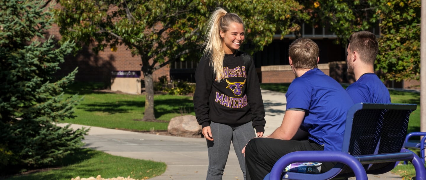 Female Minnesota State University student enjoying a chat with two male students
