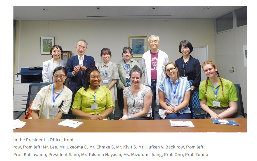 A group of ten people, some seated and some standing, are posing for a picture in a professional office setting