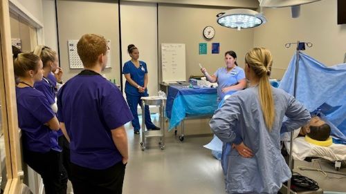A nurse talking to students in the Maverick Family Nursing Simulation Center