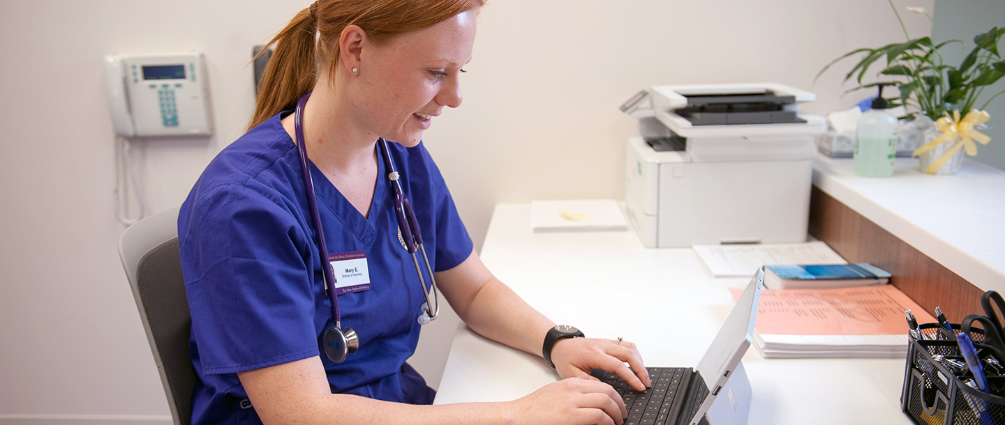 Nursing Student with laptop at front desk