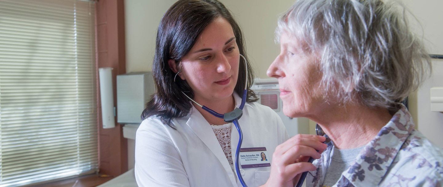MNSU registered nurse checking up on an elderly women with a stethoscope