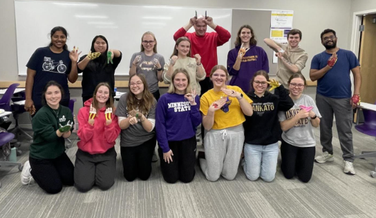 A group of students posing using sign language