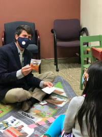 Health Commons at Pond faculty working with child on floor