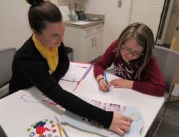 A student working with a child during a literacy and learning diagnostic session