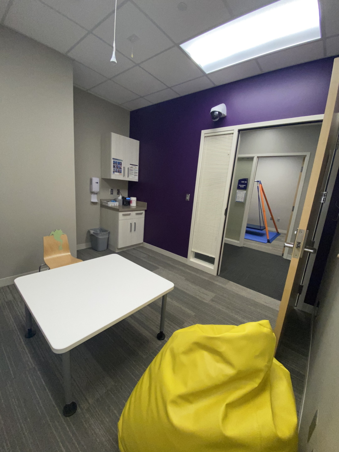 Pediatric therapy room with sink in background and table with yellow bean bag