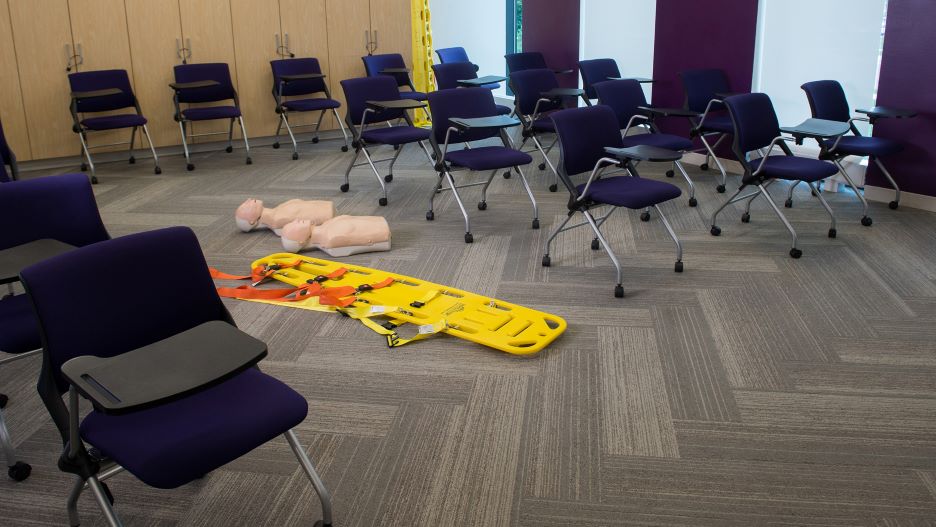a health science classroom with CPR models and a stretcher