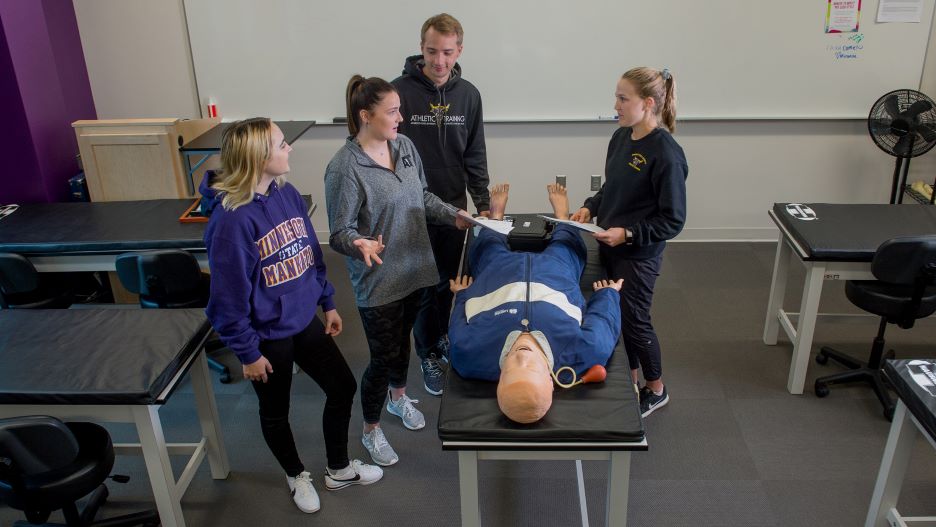 Human Performance students practicing respiratory procedures on a CPR dummy