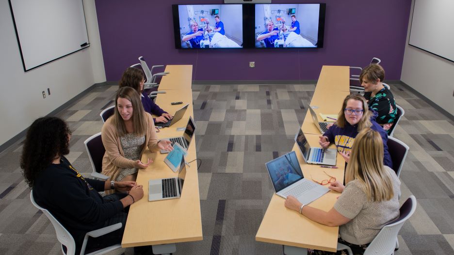 students in a nursing technology and learning classroom with laptops
