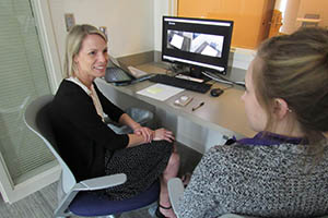 Instructor and student talking near computer