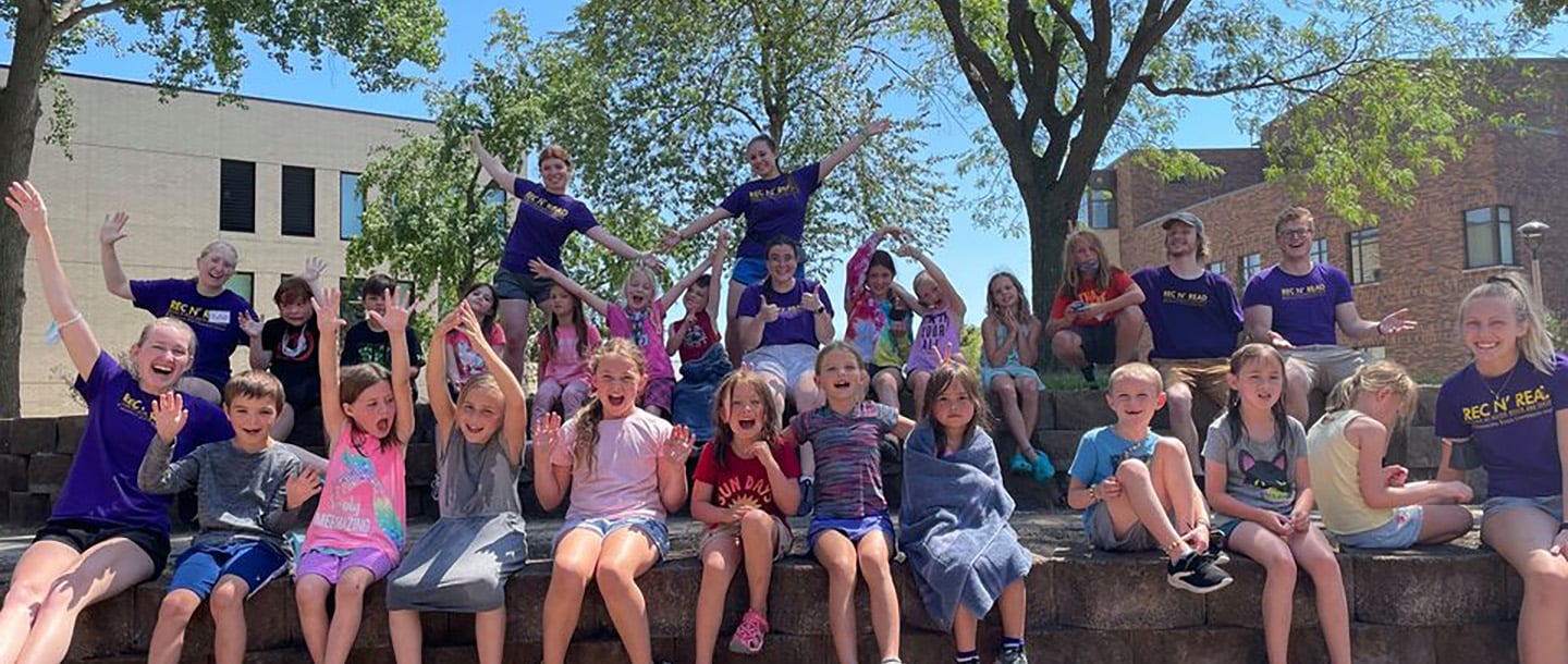Large group of Rec N' Read campers posing outside in-front of clinical science building